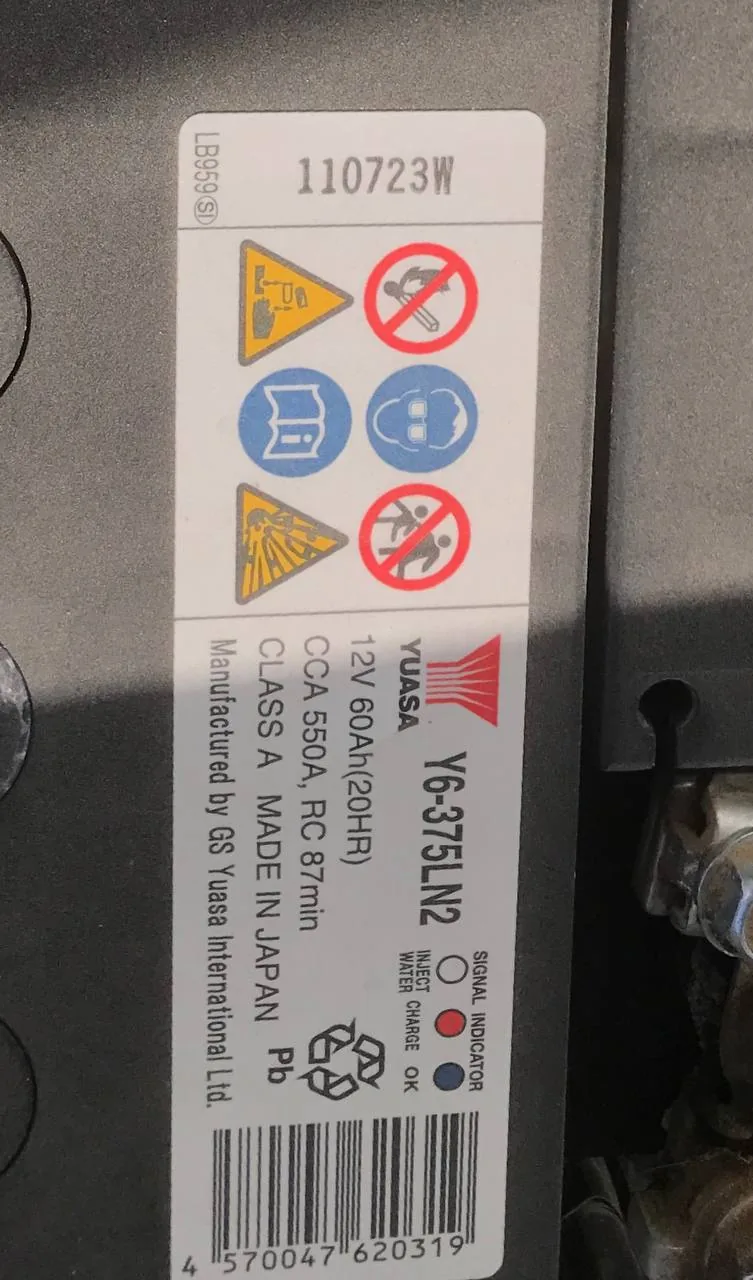 ملصق بطارية يواسا في مكينة كامري مكتوب عليه 12V 60Ah و CCA 550A
