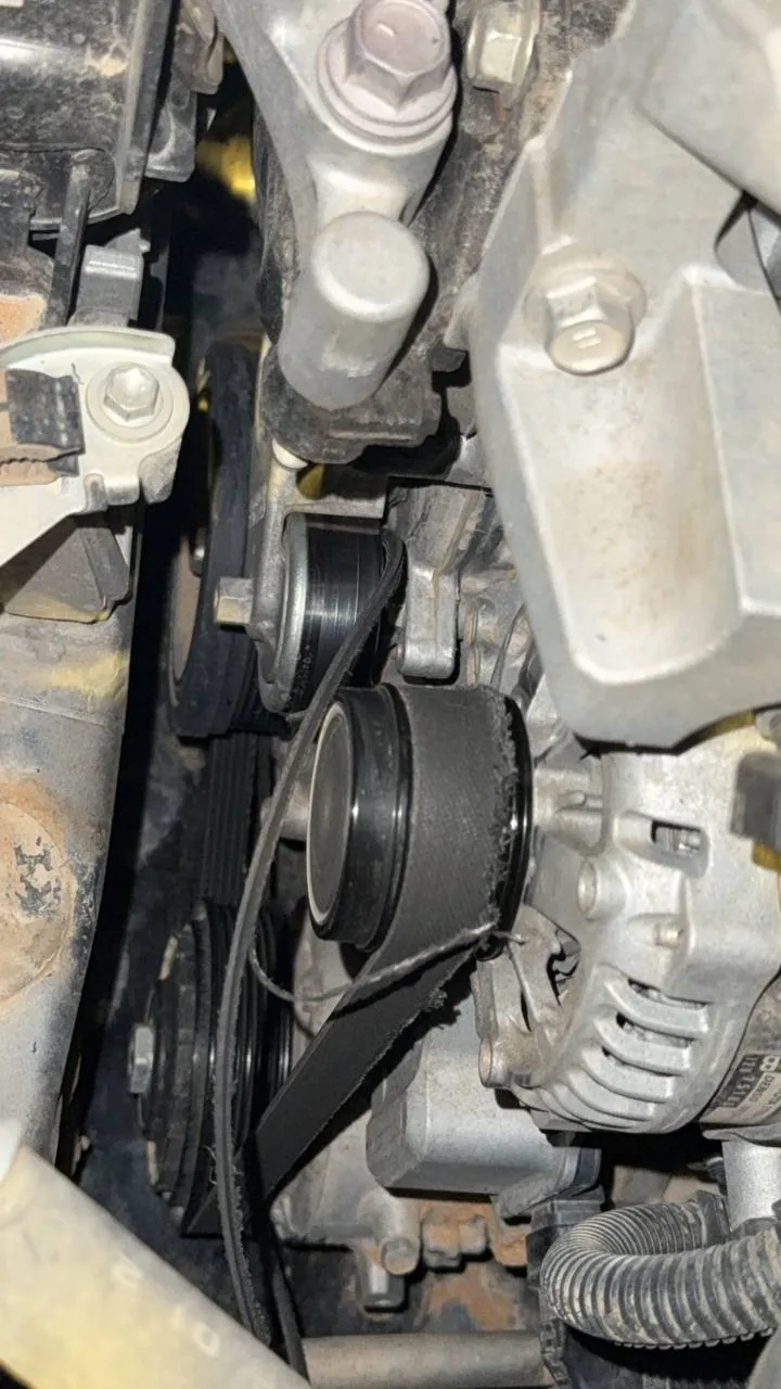 سير مكينة متآكل الحافة ومنسلخ على البكرات قرب الدينمو