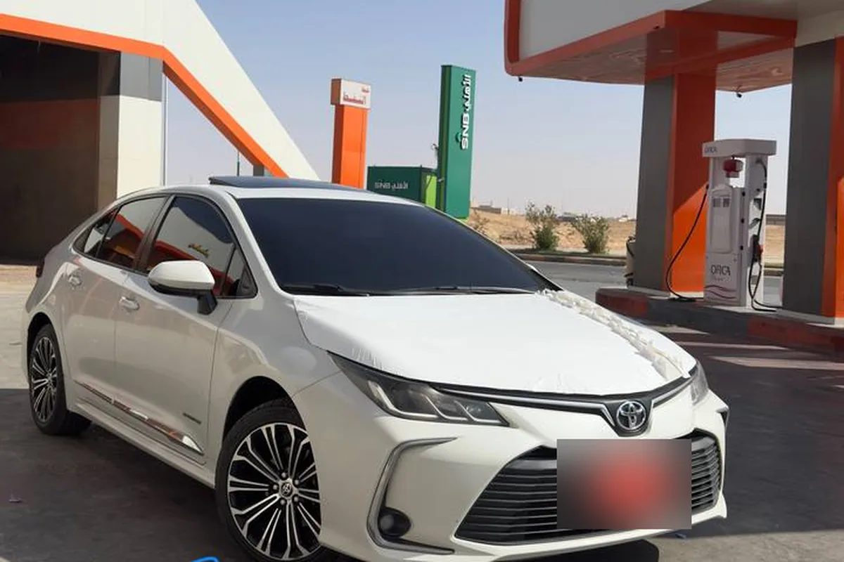 كورولا بيضاء من الجيل الحالي في محطة بنزين