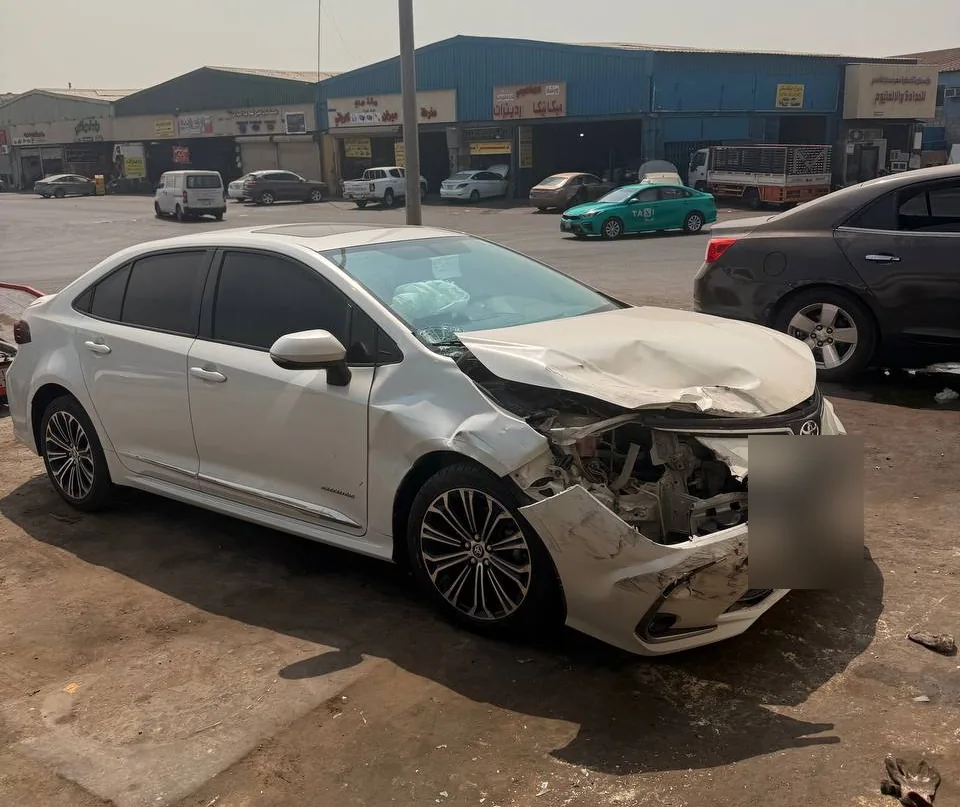 كورولا بيضاء مصدومة من الأمام في منطقة ورش