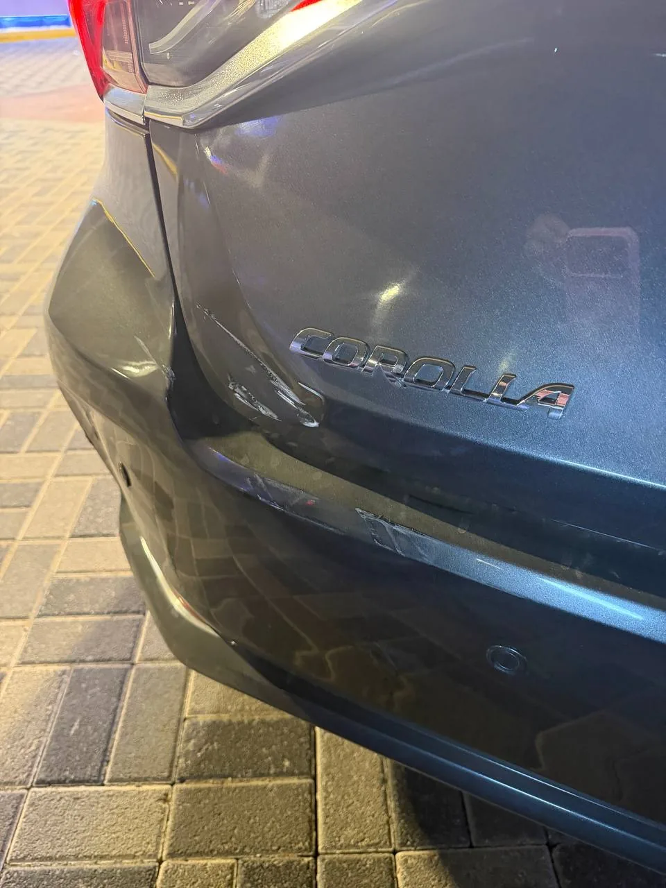 حكات على باب شنطة كورولا رمادية قرب كلمة COROLLA