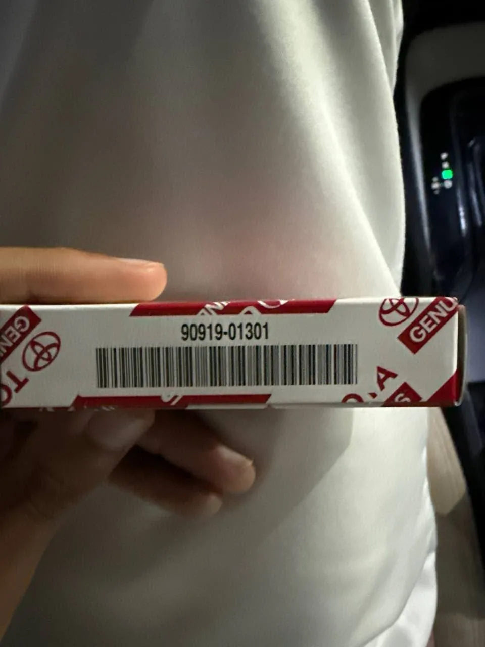 علبة بوجي تويوتا أصلي برقم 90919-01301 في يد صاحبها